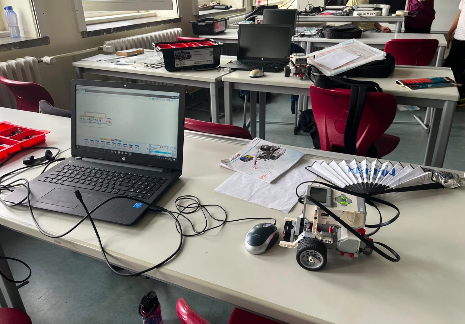 Laptop mit Programmieroberfläche neben einem fertig gebauten Lego-Mindstorms-Roboter auf dem Tisch