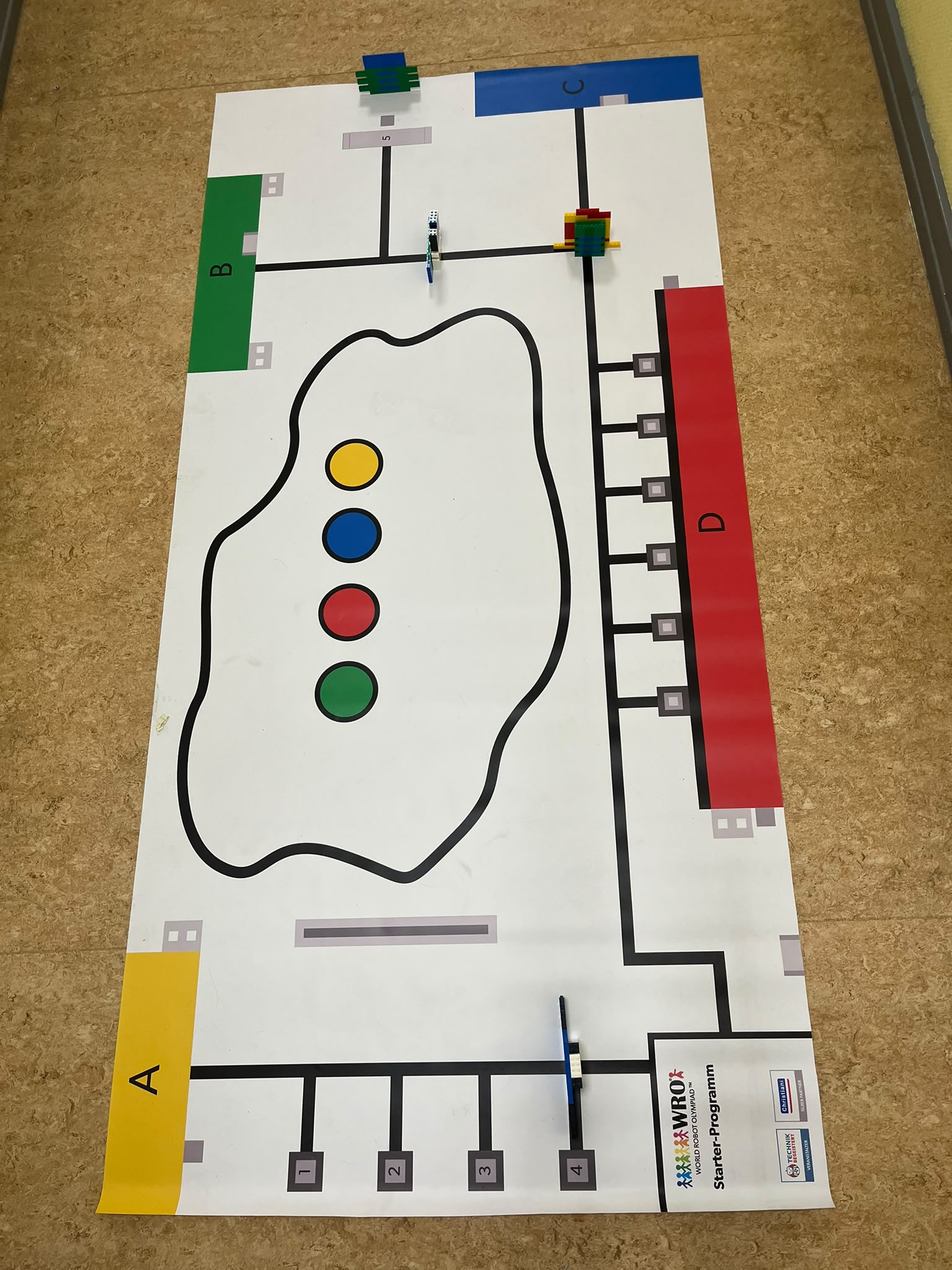 Parcours-Matte der World Robot Olympiad mit Lego-Robotern an Start- und Zielfeldern