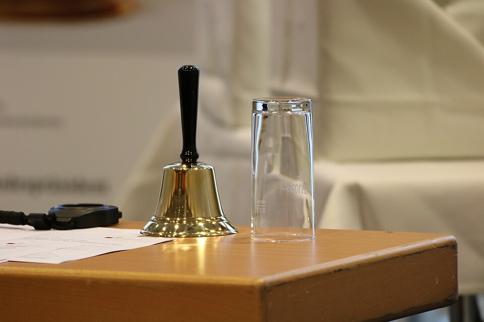 Tisch mit Handglocke und Wasserglas
